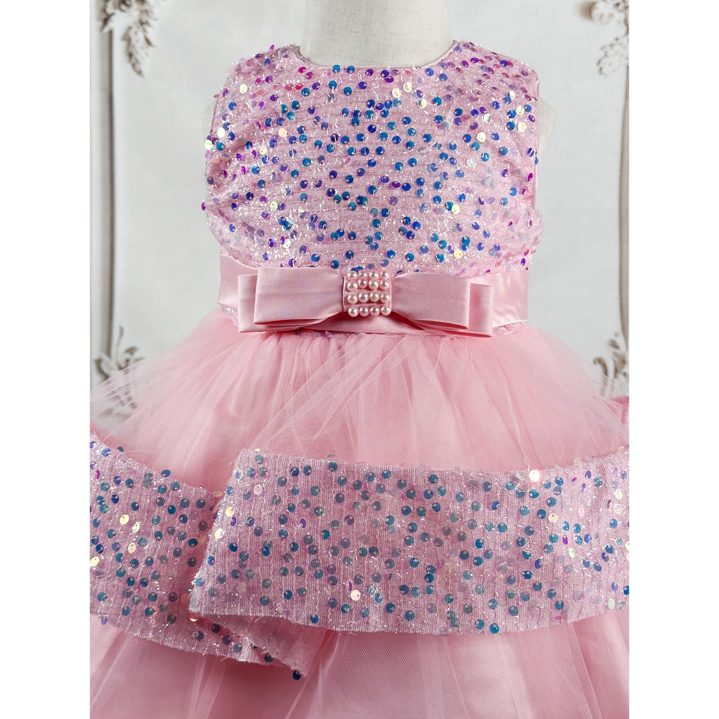 A light pink tulle dress with sequins and a bow belt