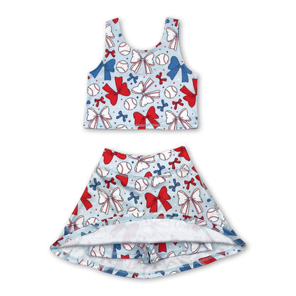 Children's tank top and skirt set with  shorts underneath, baseball and bow pattern on a white background. set is light blue with white bows, white baseballs, blue bows, red bows