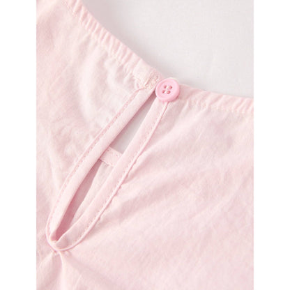 close up of back of top, closure section, closes with one light pink button that passes through a piece of elastic